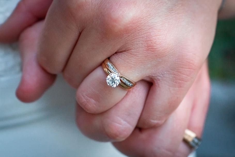engagement rings on couple's hands
